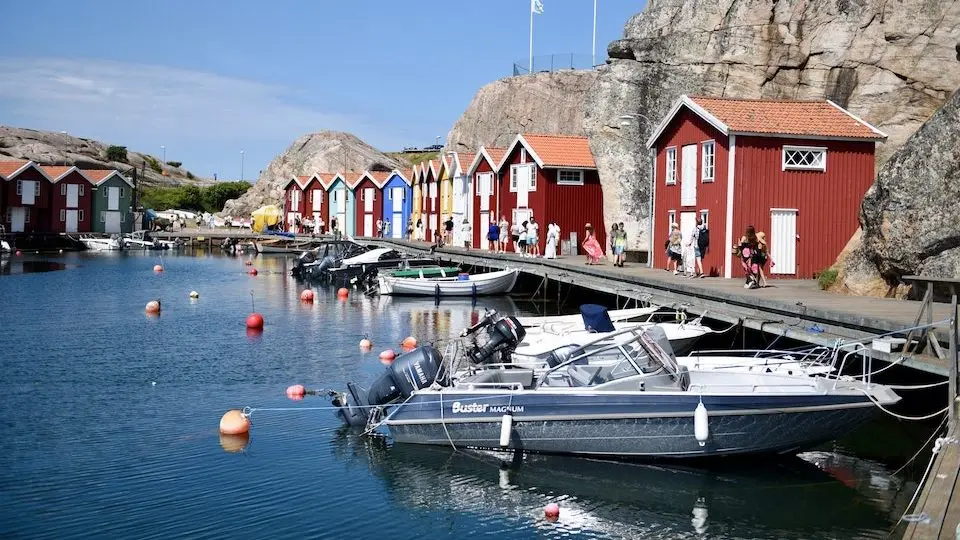 Fiskeläge med färgglada sjöbodar och båtar på västkusten