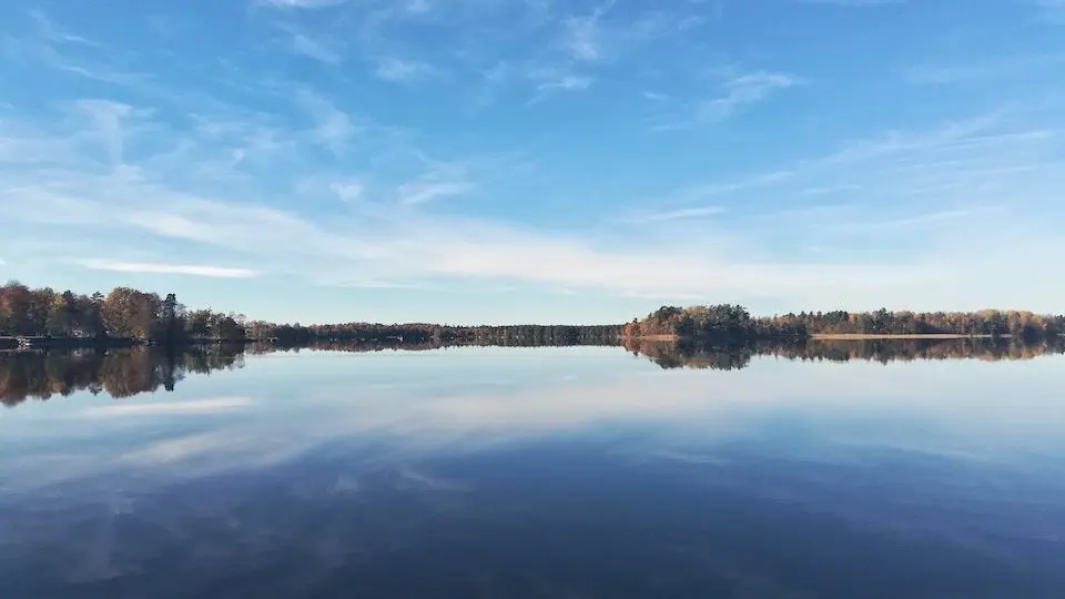 Spegelblank sjö omgiven av skog i Kronobergs län